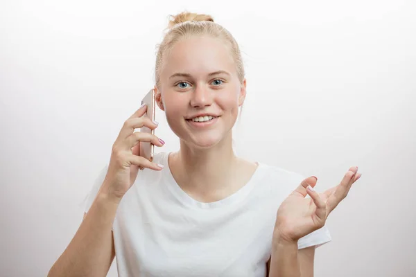 Cheerful woman holding smartphone and looking at camera over white background — Stock Photo, Image
