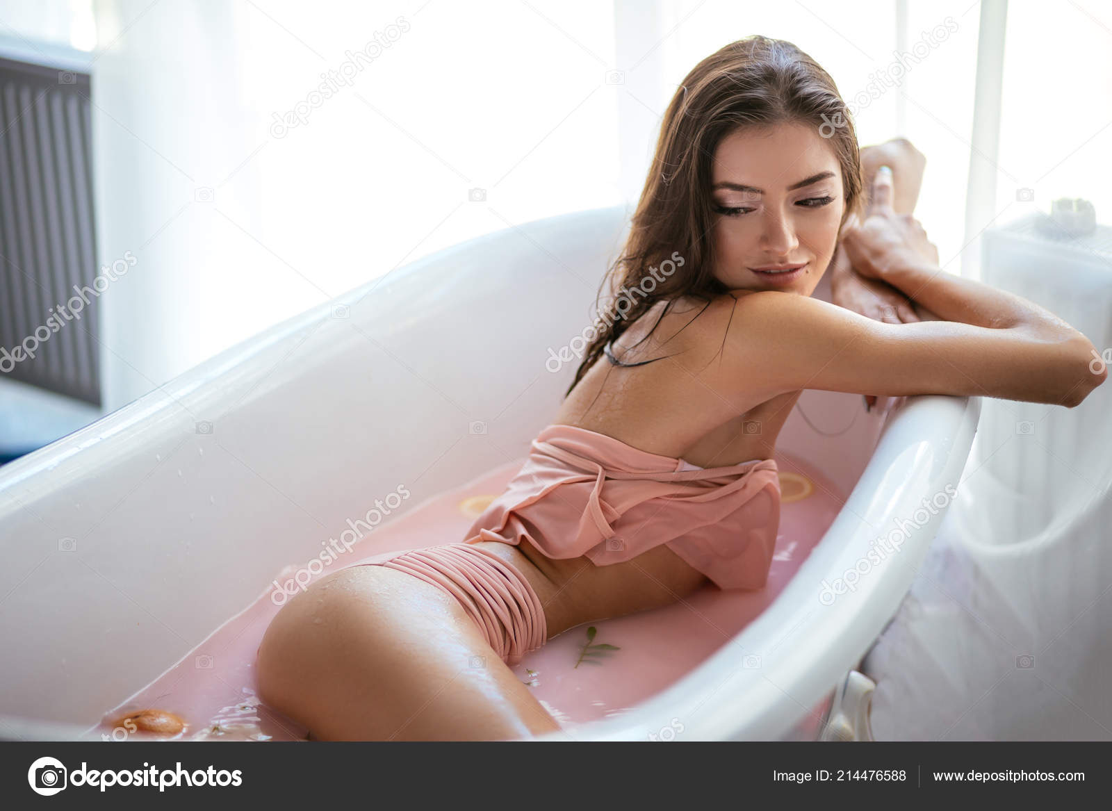Woman relaxing in milky bath in spa resort