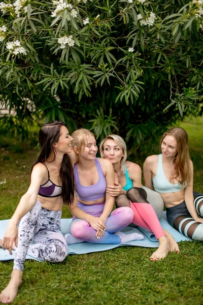Bir grup genç kadın parkta açık hava eğitiminden sonra dinleniyor. — Stok fotoğraf