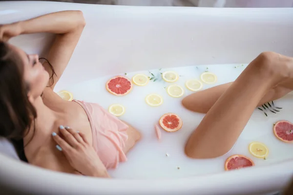 Una joven morena toma un baño de leche. — Foto de Stock