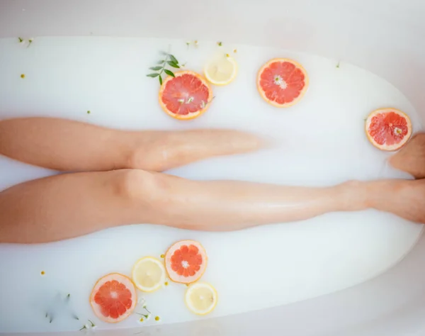 Hermosa mujer sexy en el baño de leche con frutas — Foto de Stock