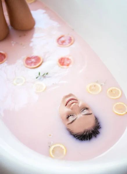 Frauengesicht im Milchbad. Spa Hautpflegekonzept. Gesundes Gesicht und Verjüngung. — Stockfoto