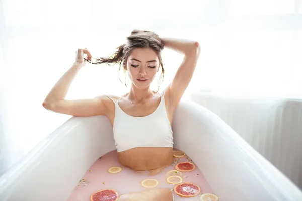 Mulher relaxante em banho leitoso em spa resort. Conceito de bem-estar e bem-estar — Fotografia de Stock