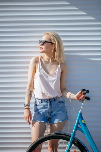 Красивая девушка с светлыми волосами с велосипедом изолированы на белом фоне. — стоковое фото