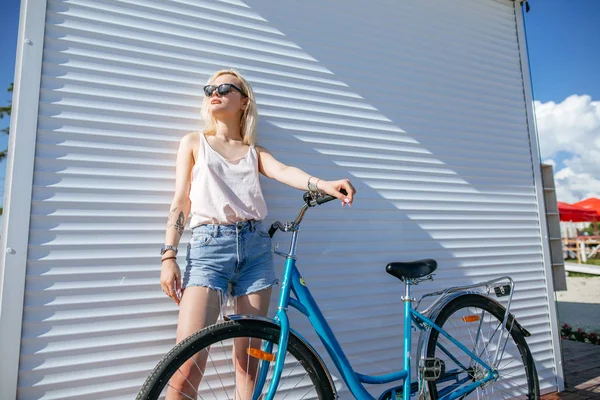 하얀 배경에 자전거를 타고 다니는 금발의 아름다운 소녀. — 스톡 사진