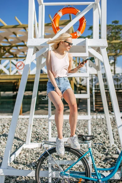 Mujer joven descansando después de ciclismo rápido en una playa de guijarros. Concepto de relajación —  Fotos de Stock