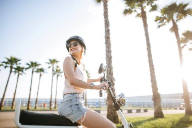 Turist kadın elektrikli bisikletle şehri geziyor.