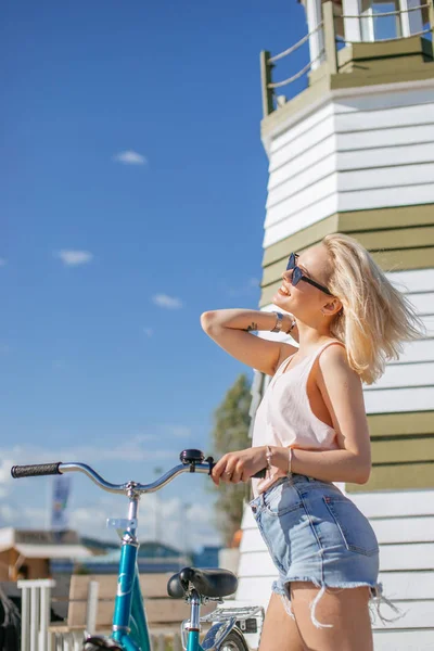 Mujer apoyada en la bicicleta mientras está de pie cerca de la plataforma de observación en la playa — Foto de Stock