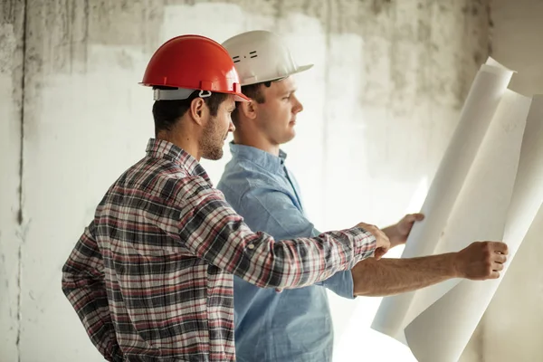 Deux ingénieurs travaillent sur la conception de la construction à l'intérieur . — Photo