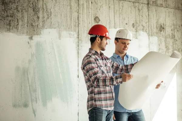 Två kreativa byggare diskuterar lotation av en ny byggnad. — Stockfoto