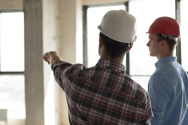 Mitarbeiter mit Helm zeigt einem Vorgesetzten den Bauort — Stockfoto