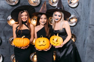 Cadı neşeli genç kadınlarda üç kabak ile Cadılar Bayramı kostümleri