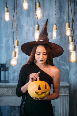 Cadılar Bayramı için kabak tutan genç sarışın kadın