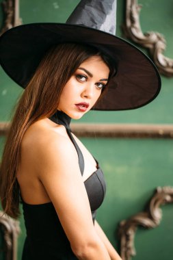 Güzel genç kadın şapka ile siyah cadı kostüm