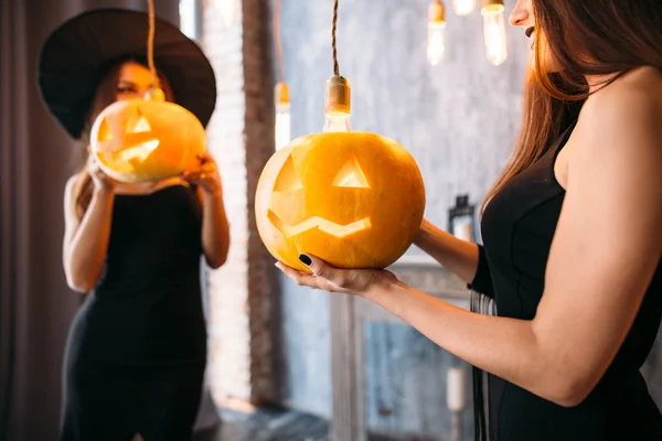 holidays, halloween, decoration and people concept - close up of woman with pumpkins at home