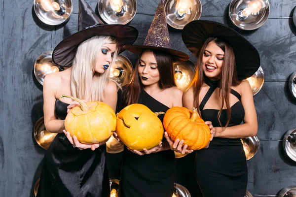 Cadı neşeli genç kadınlarda üç kabak ile Cadılar Bayramı kostümleri