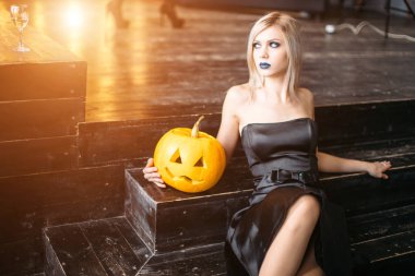 Cadılar Bayramı için kabak tutan genç sarışın kadın
