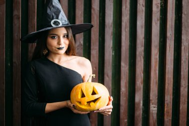 Cadılar Bayramı. Seksi Bayan kırmızı elleri üzerinde büyük kabak ile