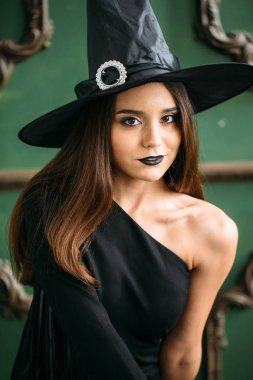 Güzel genç kadın şapka ile siyah cadı kostüm
