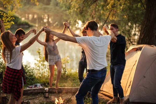 Étudiants heureux dansent autour du feu de joie — Photo