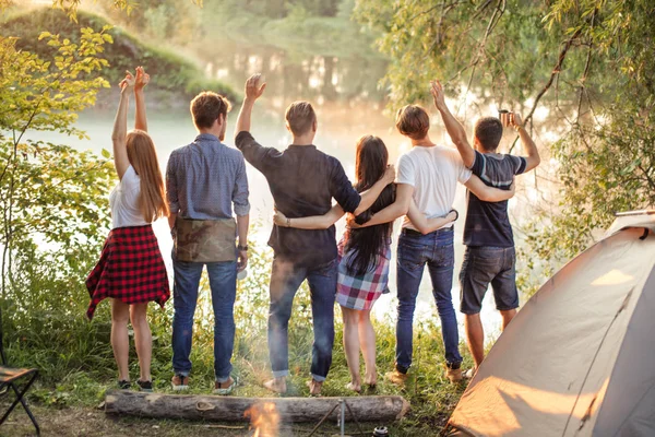 Jeunes touristes sont debout bras dans le bras ensemble et s'amuser près du lac — Photo