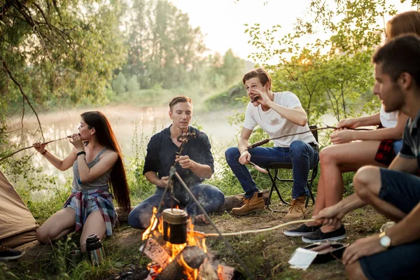 Escursionisti attraenti stanno mangiando salsicce — Foto Stock