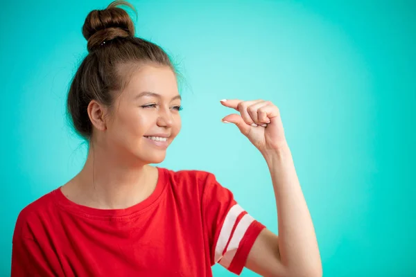 Riendo impresionante chica muestra algo invisible —  Fotos de Stock