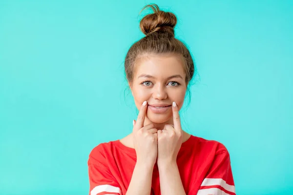 Cute smiling young woman in red stylish T-shirt touching her mouth — Stock Photo, Image