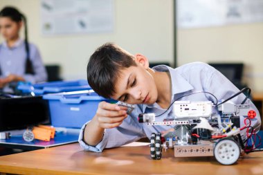 Robot okulundaki küçük çocuk robot yapıyor.