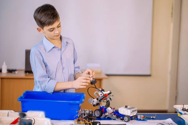 Маленький хлопчик у школі робототехніки робить робота — стокове фото