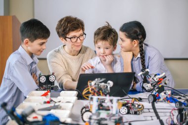Mutlu çocuklar ders dışı derslerde dizüstü bilgisayar kullanarak programlama öğrenirler.