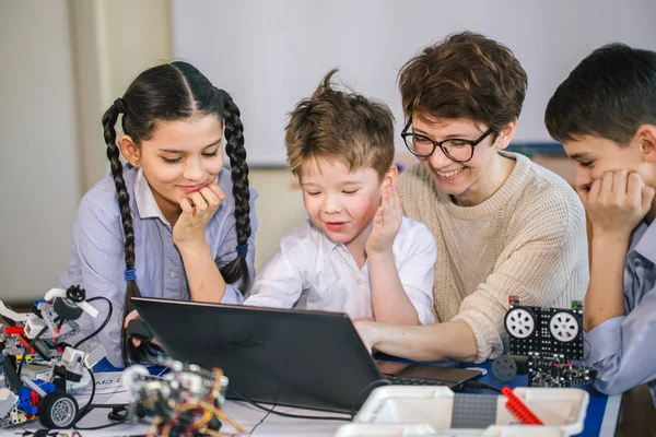 Crianças felizes aprendem programação usando laptops em aulas extracurriculares — Fotografia de Stock