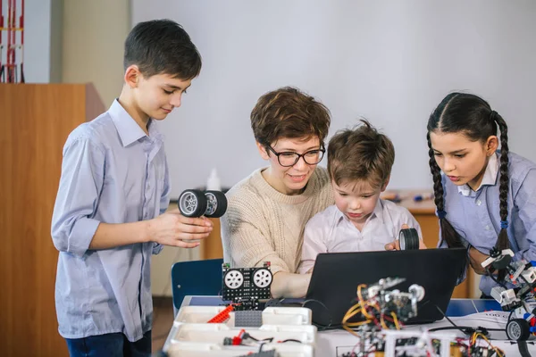 Crianças felizes aprendem programação usando laptops em aulas extracurriculares — Fotografia de Stock