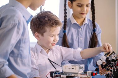 Robot sergisini ziyaret ederken çocuklar elektrikli robotla oynuyorlar