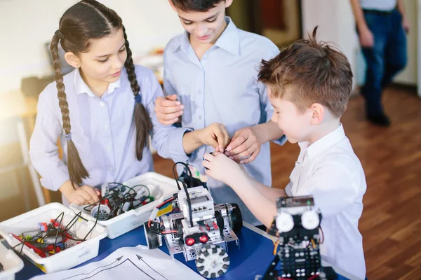 Kids playing with electrical robot while visiting robotics exhibition — Stock Photo, Image