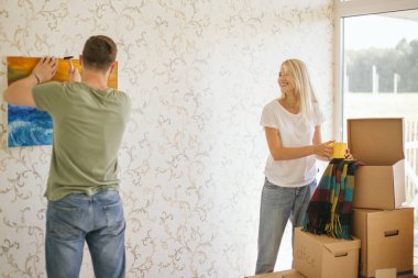 Evi taşıyorum. Yeni evin duvarına asılı bir çift resmi.