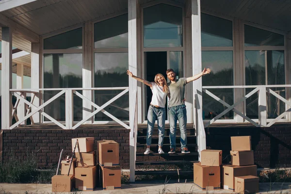 移動段ボール箱と新しい家の階段に立つカップル — ストック写真