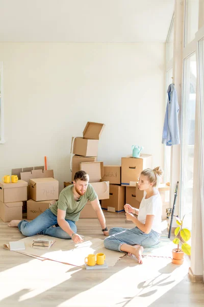 Casal procurando plantas de sua nova casa. Planejamento de interiores — Fotografia de Stock