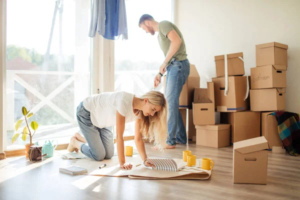 Een stel op zoek naar blauwdrukken van hun nieuwe huis. Planning interieurontwerp — Stockfoto