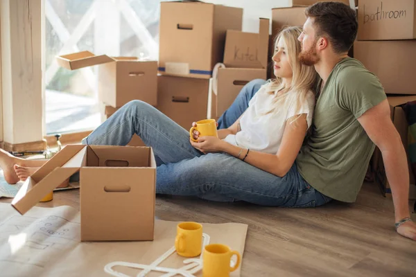 Um casal a mudar-se para casa. Pessoas felizes compram novo apartamento — Fotografia de Stock