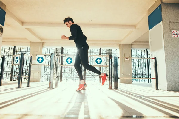 Handsome man running in sunset near fence — Stock Photo, Image