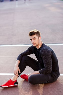 Dinlenme zamanı. Stadyumda koşan bir adam dinleniyor.