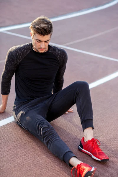 Time to rest. man resting after running on track in stadium — Stock Photo, Image