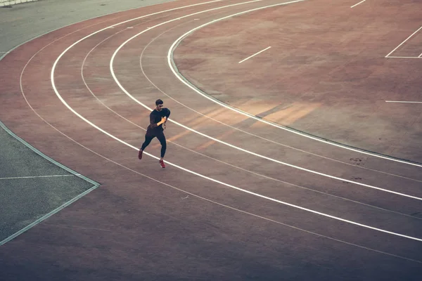 Top view Athlete running on running track. Runner sprinting on red running track in stadium — Stock Photo, Image