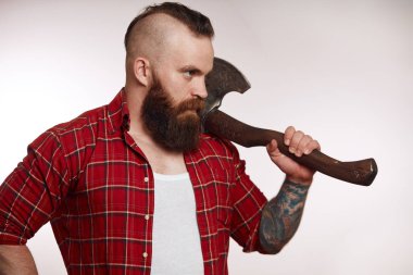 Mohawk sakallı erkek, beyaz arka planda omzunda balta taşıyor.
