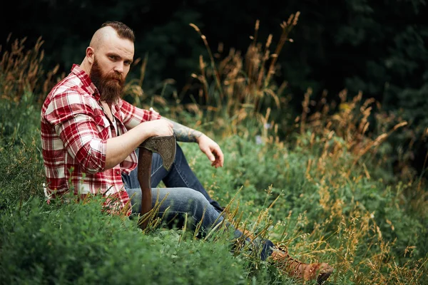 Lumberjack sitting in forest resting after hard work — Stock Photo, Image