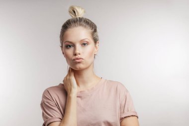 Beyaz arka planda kameraya gülümseyen neşeli genç kız..