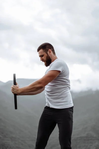 Handsome muscular hunk man looking at mountains from the peak. — Stock Photo, Image