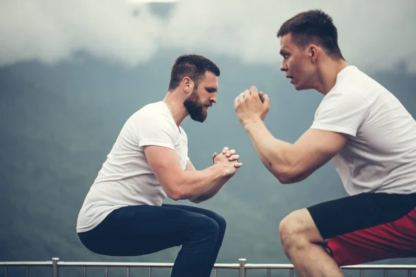 Dos amigos atléticos masculinos haciendo ejercicio de salto de caja al aire libre — Foto de Stock