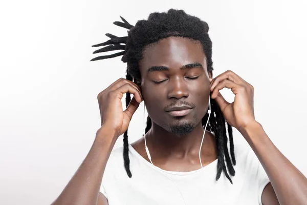 Uomo dalla pelle scura con dreadlocks ascoltare musica su cuffie — Foto Stock